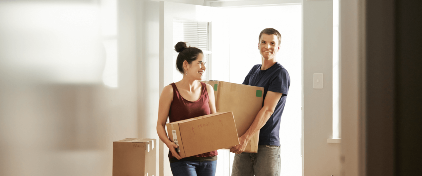 people with boxes moving into a house