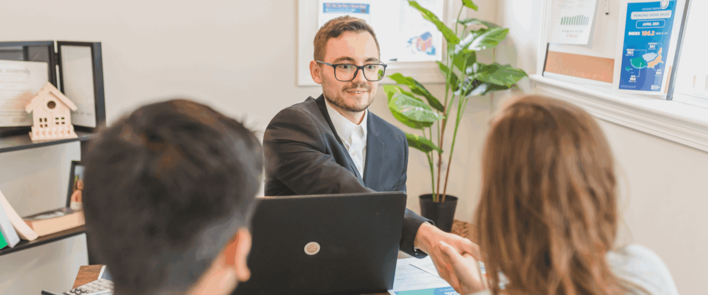 A couple speaking to an agent about how long their mortgage application will take.
