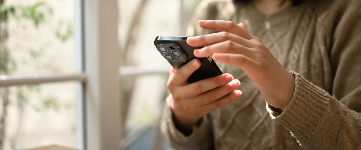 A woman on her phone looking up how to improve her 750 credit score.