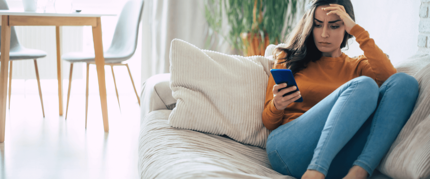 A woman on her phone, looking up how to improve her 636 credit score.