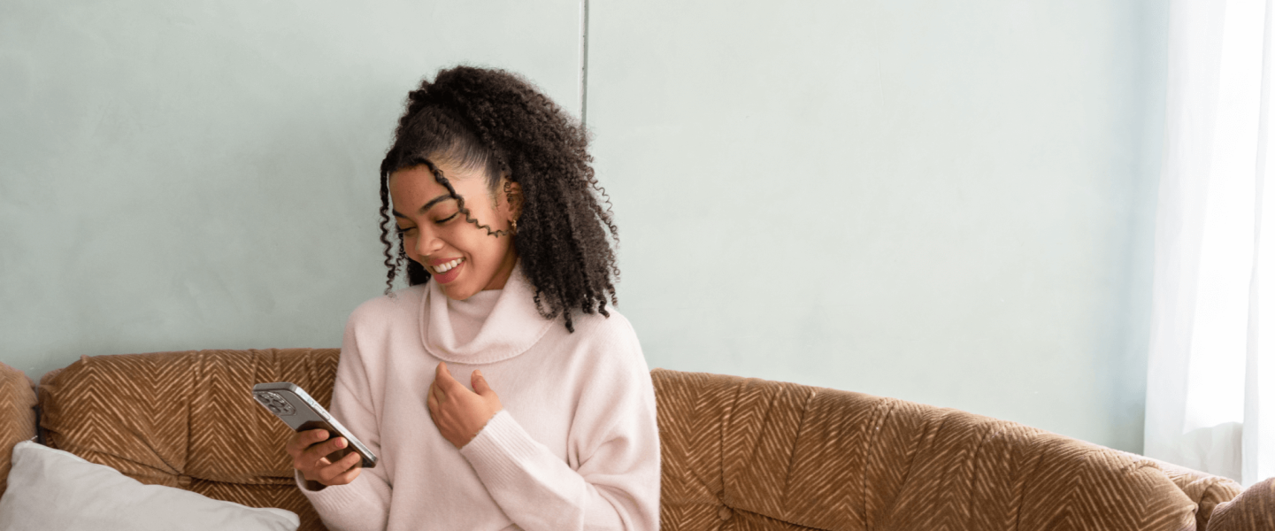 A woman on her phone looking up what a 603 credit score means.