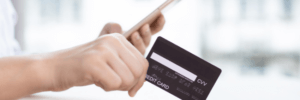 Person on their phone holding a credit card