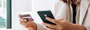 Person on their phone and using their credit card.